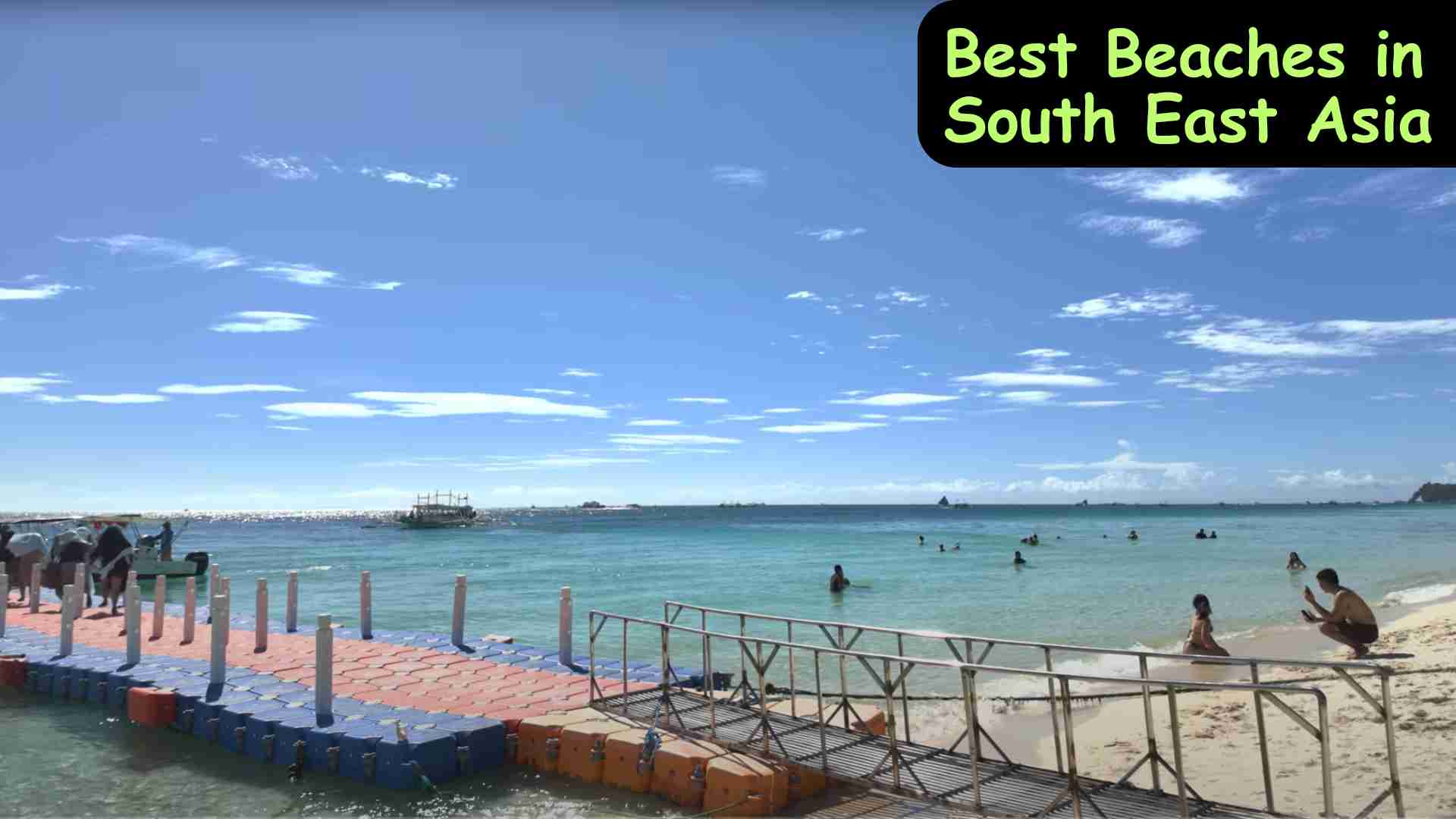 A scenic view of the best beaches in South East Asia with white sandy shores, turquoise waters, and tropical palm trees under a clear blue sky.