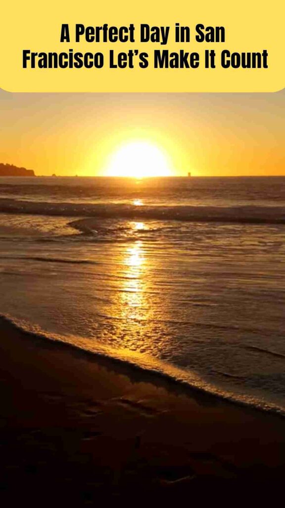 Golden Gate Bridge at sunrise viewed from Baker Beach in San Francisco, with gentle ocean waves, soft morning fog, and the city’s skyline glowing in warm light.